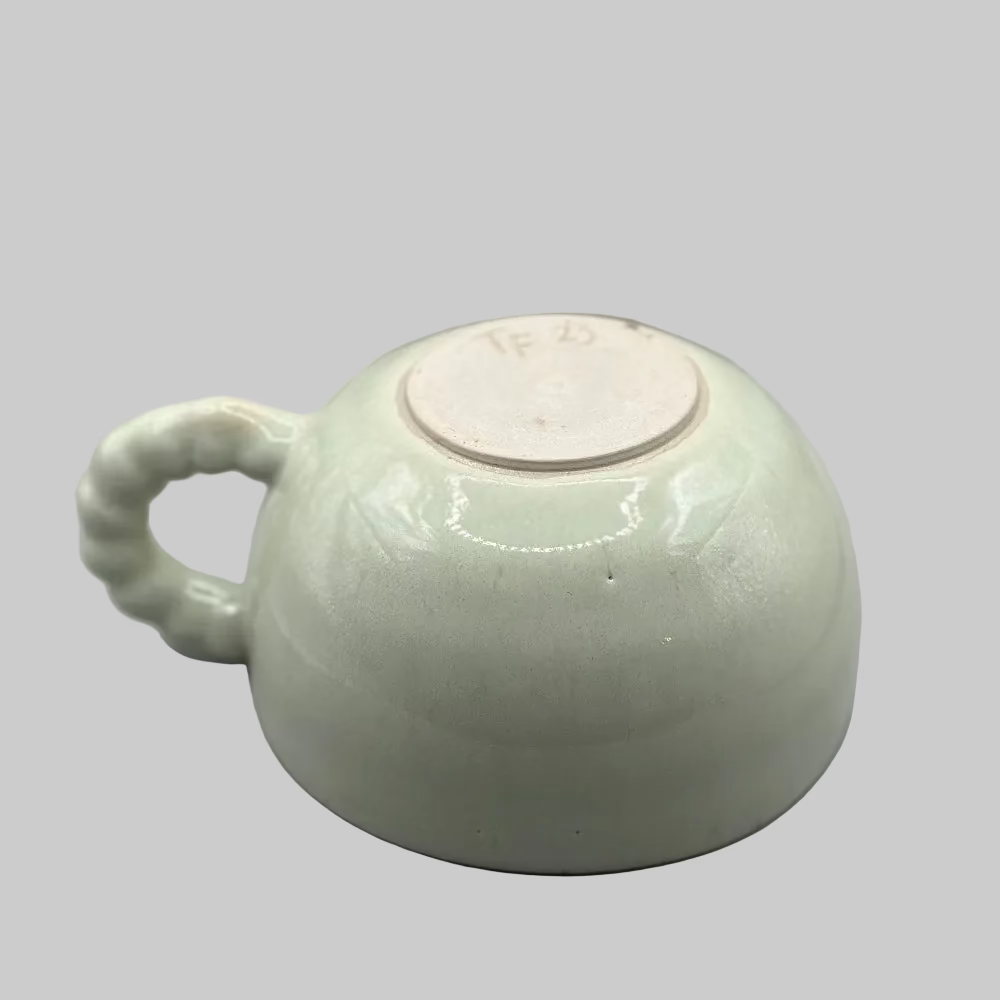 Krus i lys grøn keramik med perlehank – perfekt til kaffe eller te.