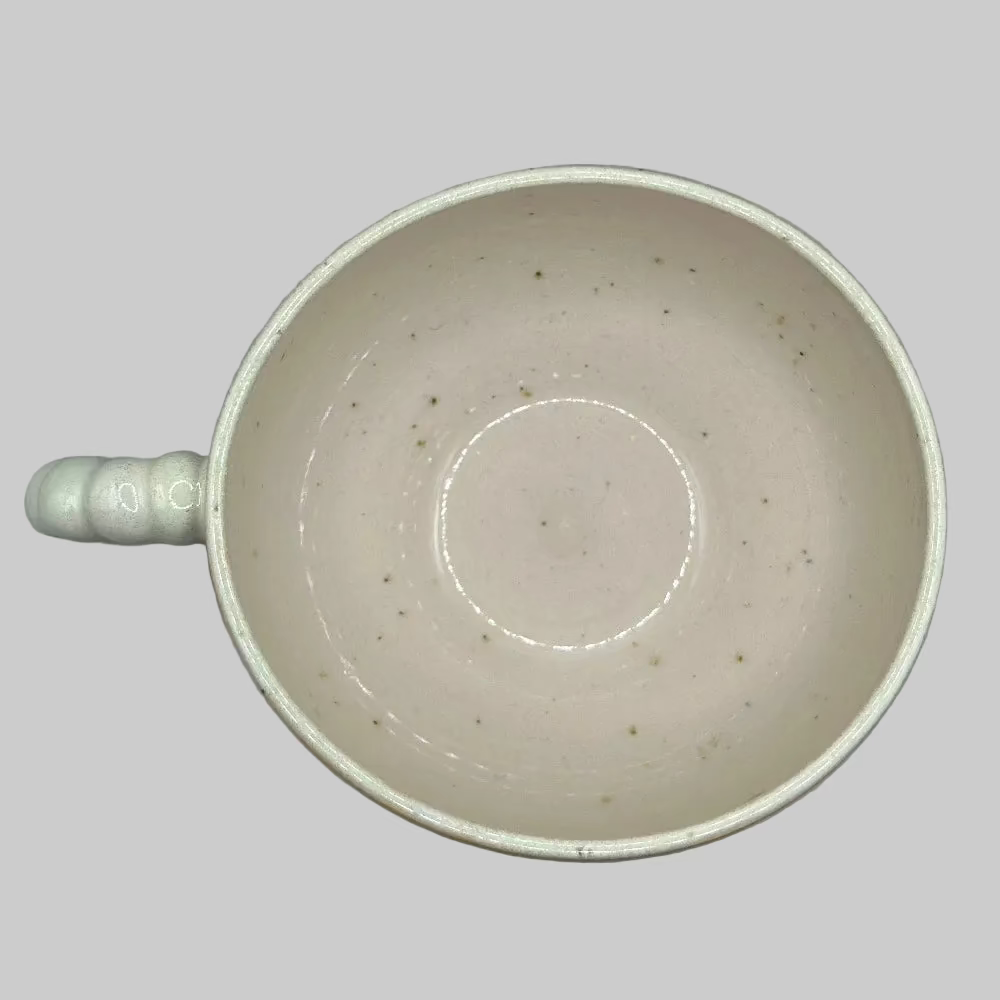 Krus i lys grøn keramik med perlehank – perfekt til kaffe eller te.