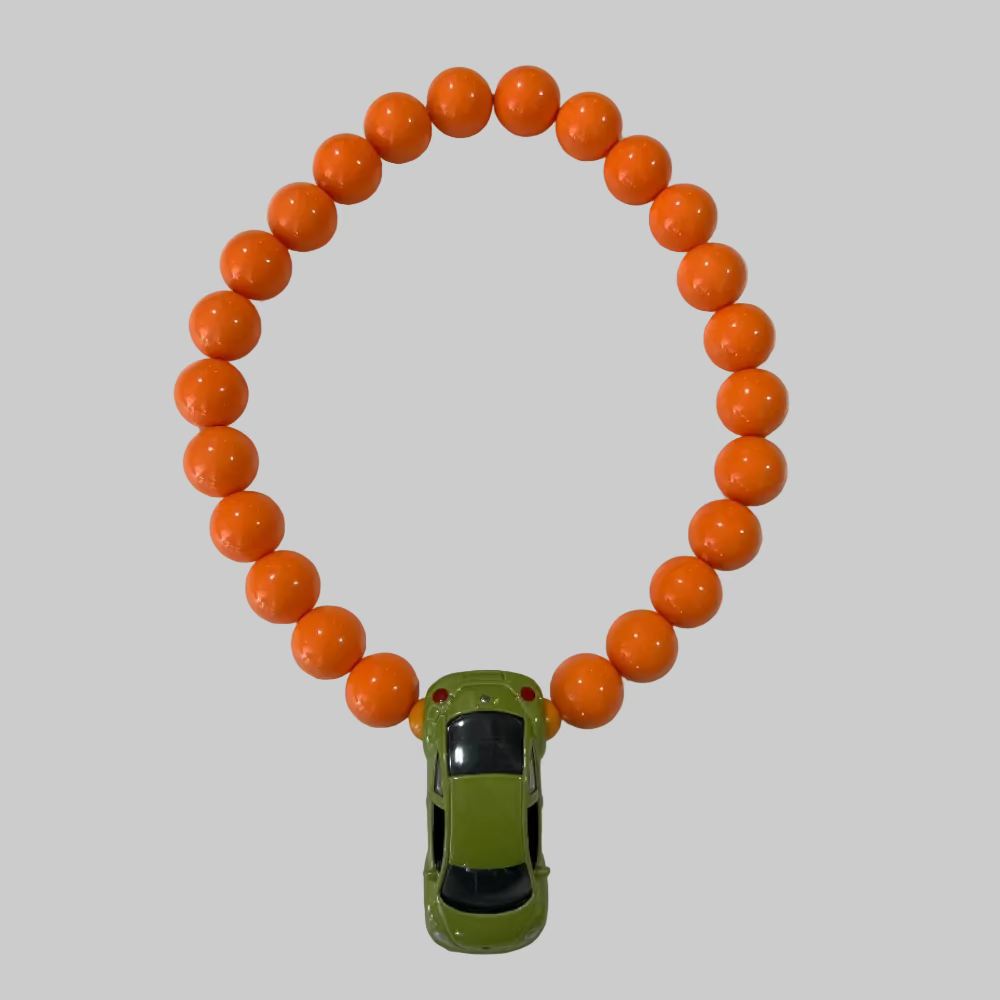 Halskæde / Bil / folkevogn boble-inspireret / Store orange perler. Halskæde med grøn bil vedhæng fra Jack of all Arts – håndlavet smykke med perler.